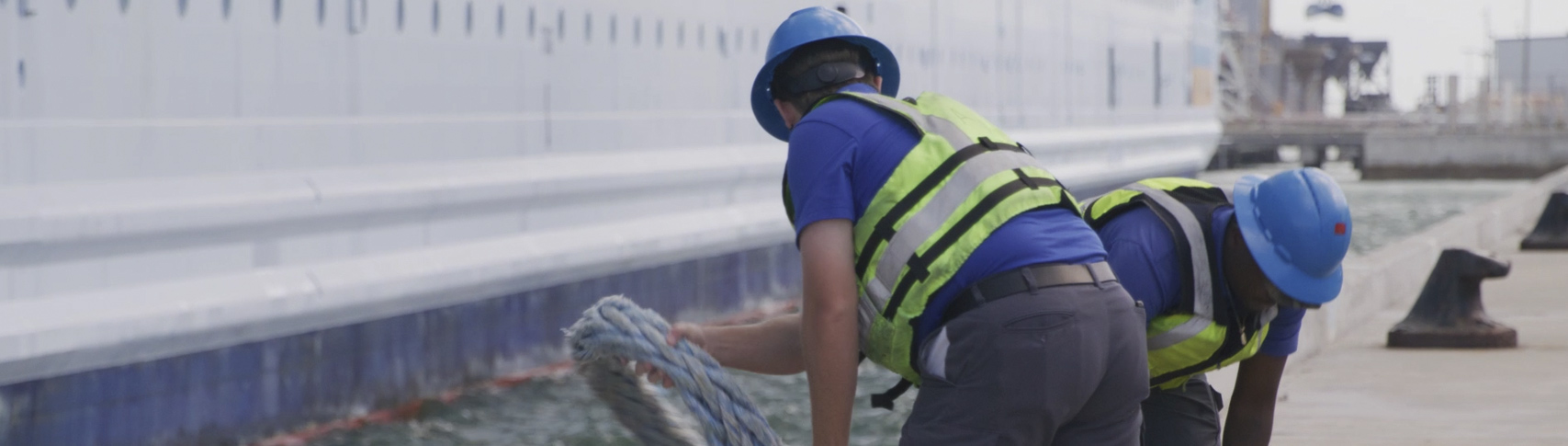 Two line handlers releasing the ropes from a cruise ship