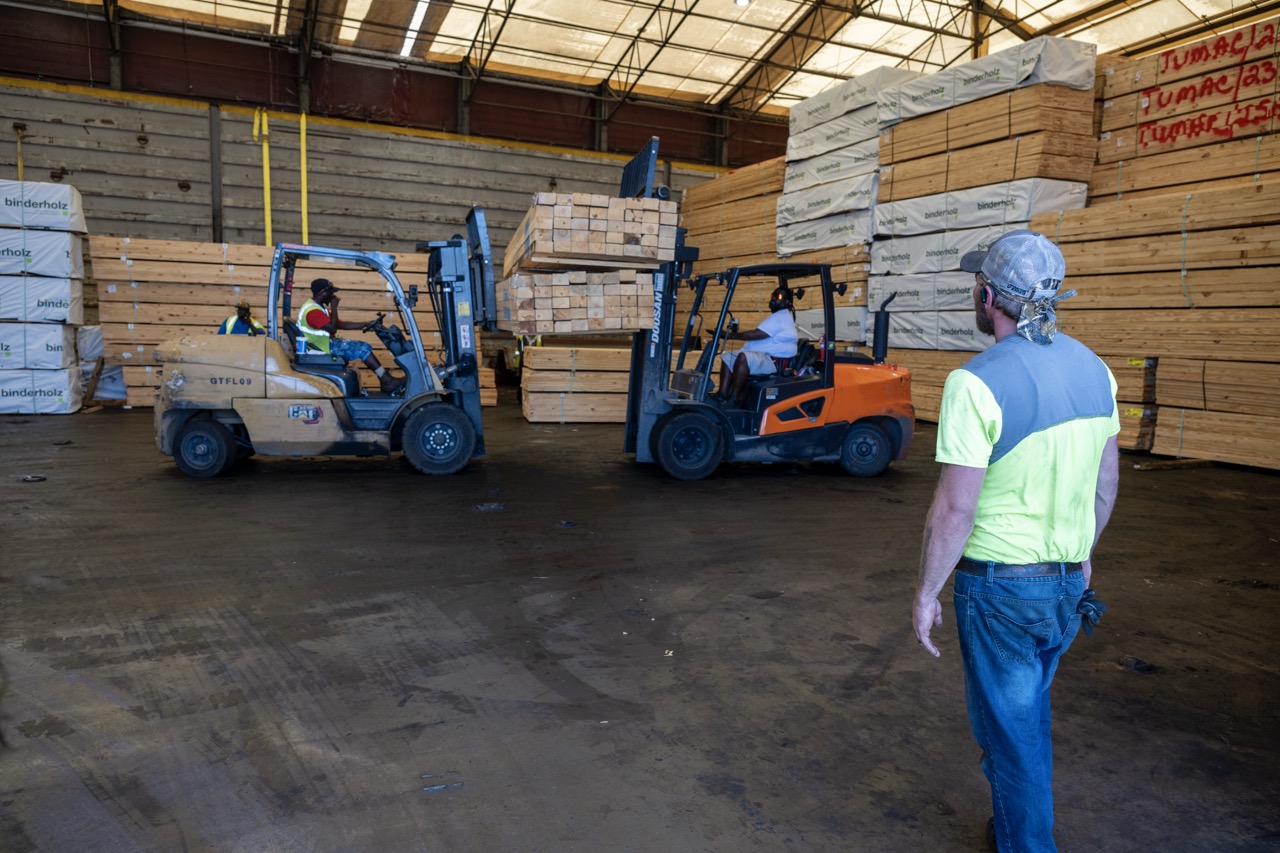 Crew loads lumber onboard the Crimson Clover warehouses barge
