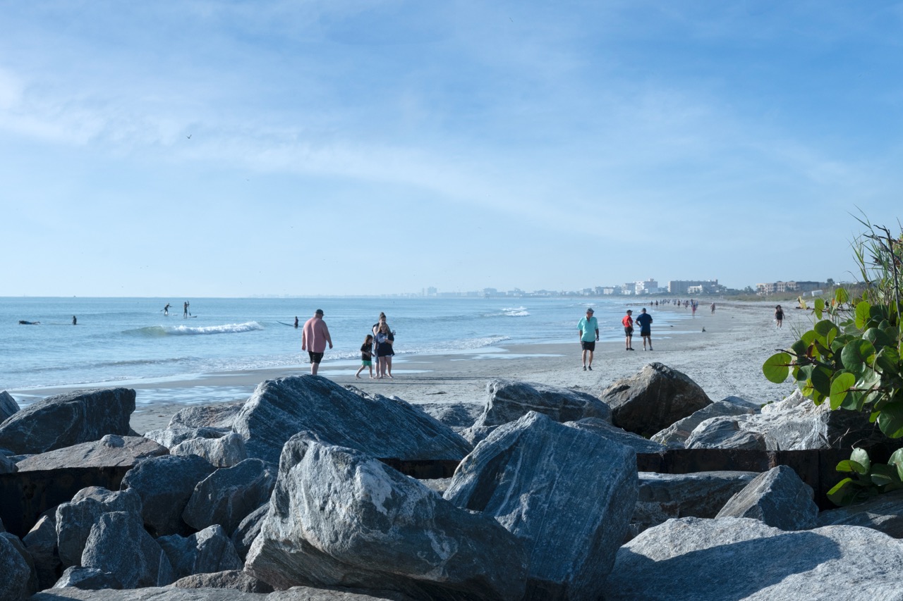 BeachgoerswalkalongtheAtlanticshoreatJettyParkbeachaccess