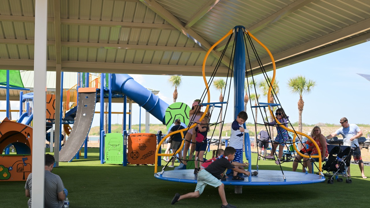 AbrandnewJettyParkplaygroundisbustlingwithchildrenplayingonshadedequipment