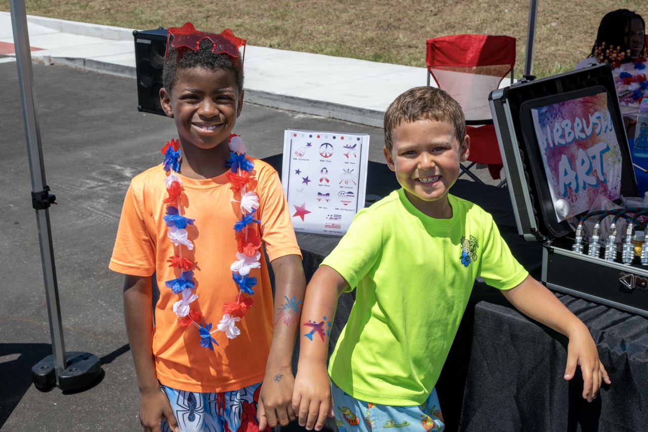 TwochildrenatJettyParkposewithairbrushedtemporarytattoosduringaspecialFlagDayevent