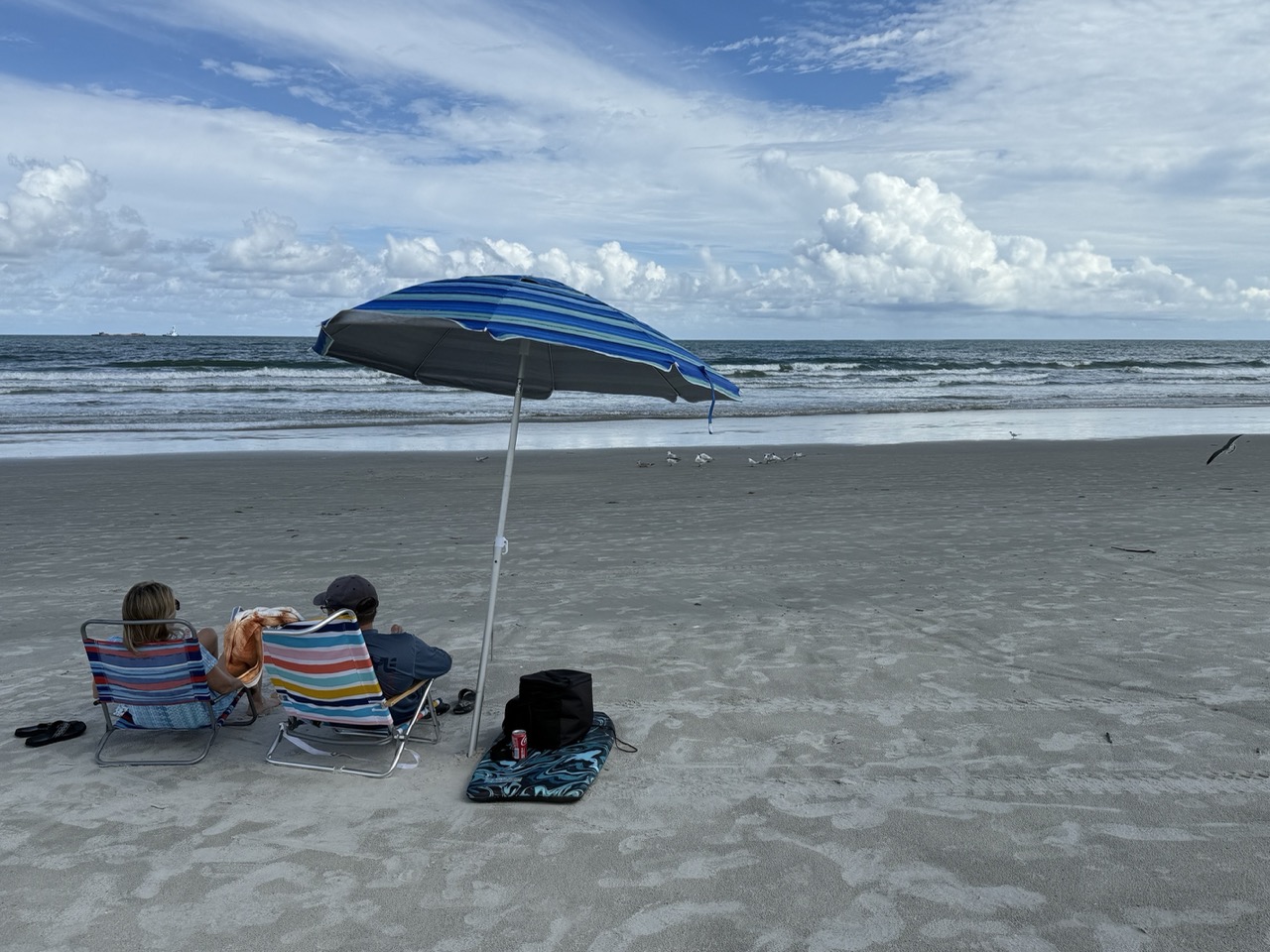 BeachgoersrelaxunderanumbrellaatJettyPark
